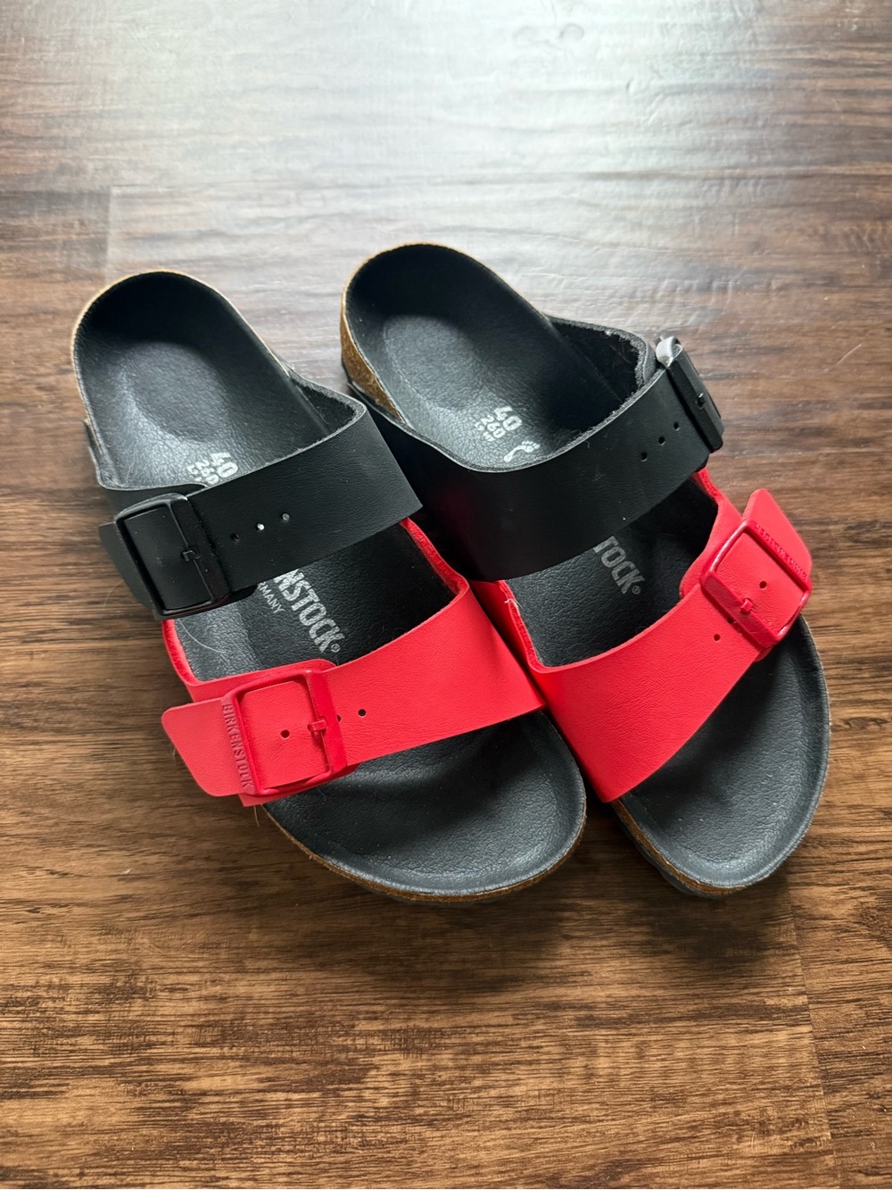 Birkenstock Arizona Split sandals featuring a red and black color-blocked design